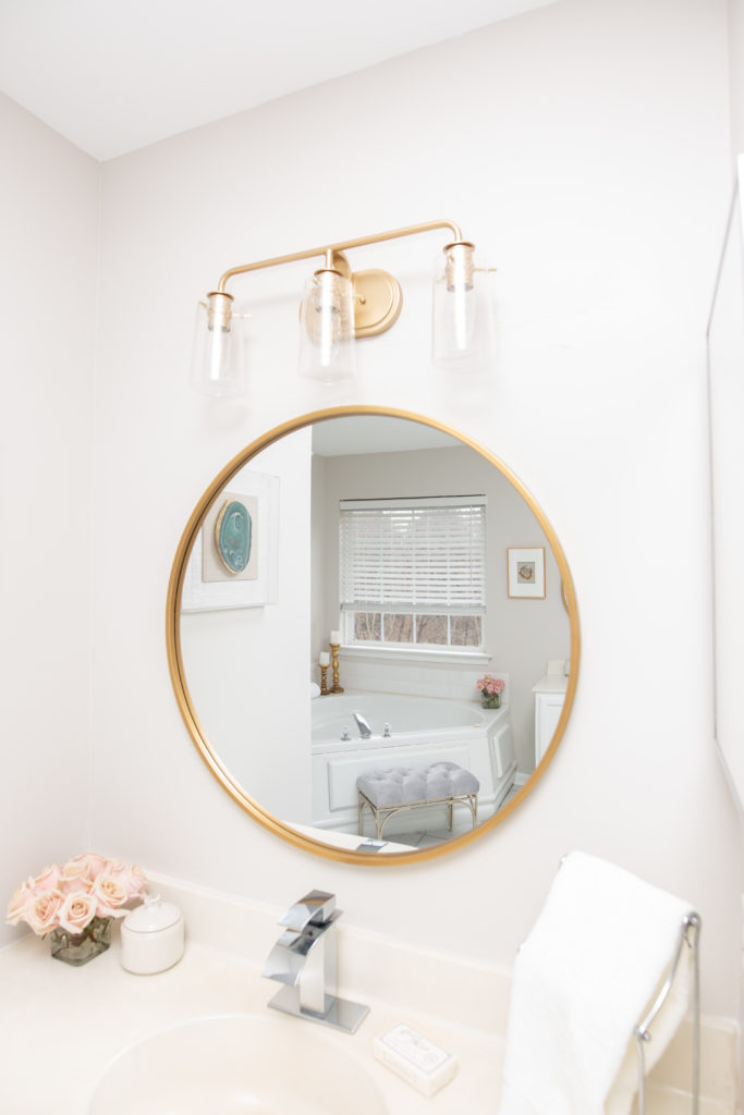 32” gold round mirror in builder grade bathroom