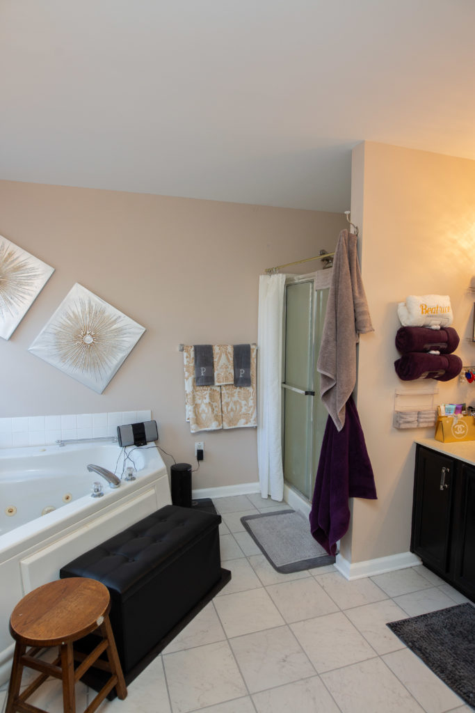 Cluttered bathroom with beige painted walls